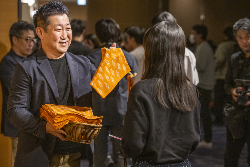 バンダナを配る吉田社長